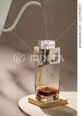 Hot water is being poured into a drip bag to brew coffee. Hot water is being poured into a drip bag to brew coffee. 123792657