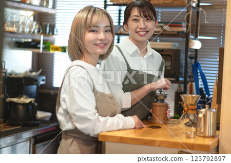 Barista and cafe clerk grinding coffee beans 123792897