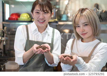 兩個穿著圍裙的女人拿著咖啡豆 123793291