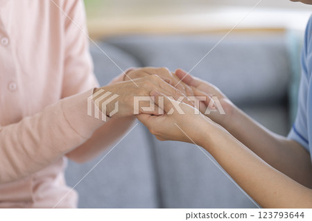 Caregiver's hand holding a senior woman's hand Caregiver's hand holding a senior woman's hand 123793644
