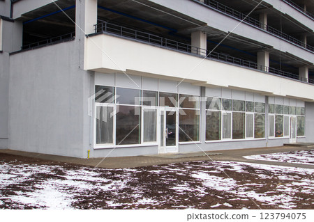 A large building that features numerous windows and multiple doors 123794075