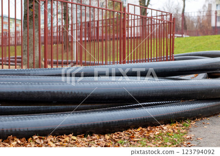 A bunch of black pipes are carefully stacked on top of each other A bunch of black pipes are carefully stacked on top of each other 123794092