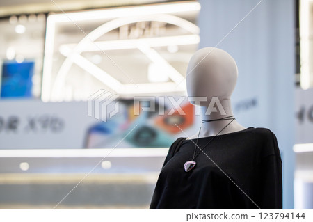 A stylish mannequin in a black sweater adorned with a necklace 123794144