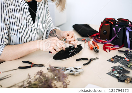 Jewelry artisan crafting handmade accessories at a workshop. Rise of sustainable handmade products and personalized craftsmanship 123794373