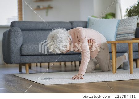 Senior woman collapses while holding her chest Senior woman collapses while holding her chest 123794411