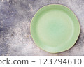 Green plate is on grey surface 123794610