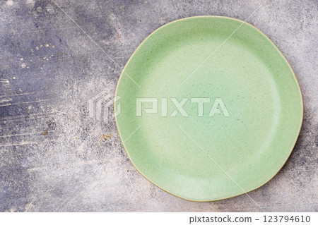 Green plate is on grey surface 123794610