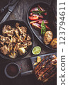 Grilled meats vegetables and potatoes on wooden boards 123794611