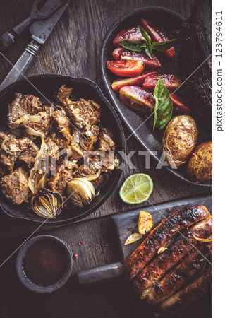 Grilled meats vegetables and potatoes on wooden boards 123794611