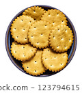 Round golden-brown crackers with scalloped edges in bowl 123794615