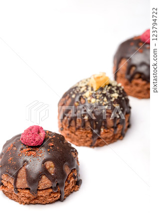 Round chocolate cakes. Decorated with candied raspberries. Light background Round chocolate cakes. Decorated with candied raspberries. Light background 123794722
