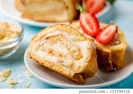 Sliced rolls with custard. The dessert is decorated with fresh strawberries Sliced rolls with custard. The dessert is decorated with fresh strawberries 123794726