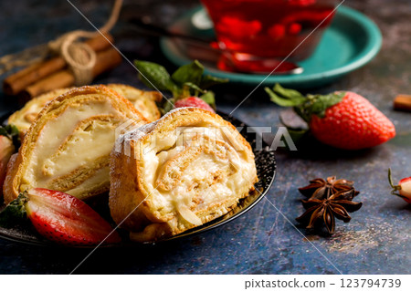 Sliced rolls with custard. The dessert is decorated with fresh strawberries Sliced rolls with custard. The dessert is decorated with fresh strawberries 123794739