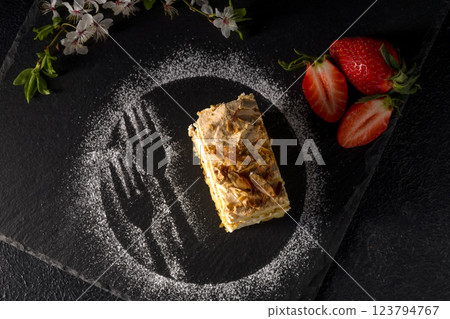Norwegian cake. With meringue, whipped cream and almonds. Dark background 123794767