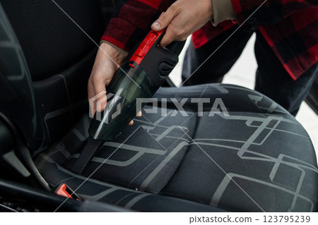 Cleaning the interior of the car with a vehicle vacuum cleaner. Cleaning the interior of the car with a vehicle vacuum cleaner. 123795239