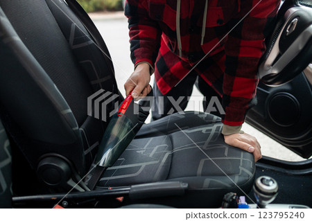 Cleaning the interior of the car with a vehicle vacuum cleaner. Cleaning the interior of the car with a vehicle vacuum cleaner. 123795240