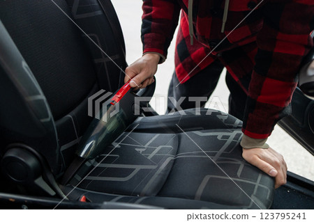 Cleaning the interior of the car with a vehicle vacuum cleaner. Cleaning the interior of the car with a vehicle vacuum cleaner. 123795241