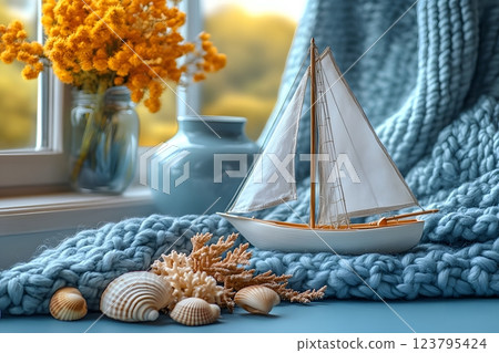 Coastal Themed Decor with Model Sailboat, Shells, and Knitted Blanket by Window Generative AI Coastal Themed Decor with Model Sailboat, Shells, and Knitted Blanket by Window Generative AI 123795424