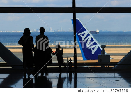 Passengers looking at the runway from the international area of Haneda Airport's Terminal 2 Silhouette of passengers looking at the runway Passengers looking at the runway from the international area of Haneda Airport's Terminal 2 Silhouette of passengers looking at the runway 123795518
