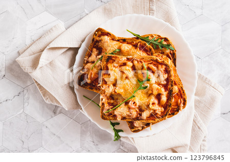 Close up of toasts with bacon, cheese and tomato sauce on a plate on the table top view 123796845