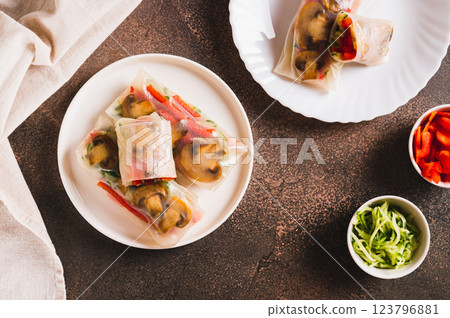 Vegetarian spring rolls with cucumber, pepper and fried mushrooms on a plate top view Vegetarian spring rolls with cucumber, pepper and fried mushrooms on a plate top view 123796881