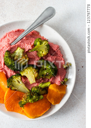 A healthy, balanced breakfast with beetroot hummus, roasted sweet potatoes, and broccoli, topped with a fresh pink radish and Chinese cabbage salad with chia seeds A healthy, balanced breakfast with beetroot hummus, roasted sweet potatoes, and broccoli, topped with a fresh pink radish and Chinese cabbage salad with chia seeds 123797778