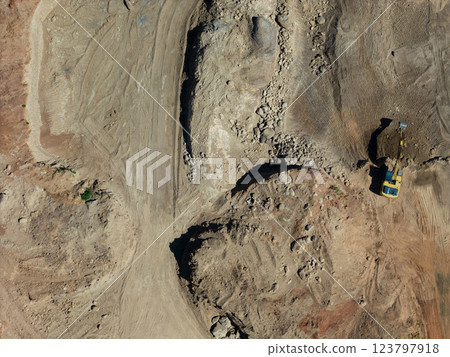 Construction site with heavy machinery at work during daylight hours in open terrain 123797918