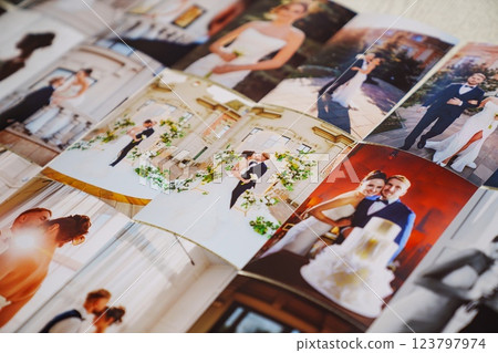 Printed wedding photos laid out on a wooden surface. 123797974