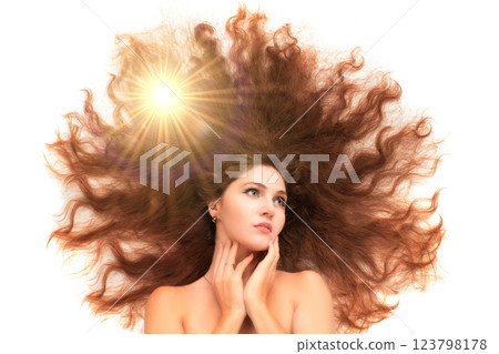 A beautiful woman is a beauty with scattered long hair through which rays of optical light break through on a white background. The concept of skin care, hair and women's health. 123798178