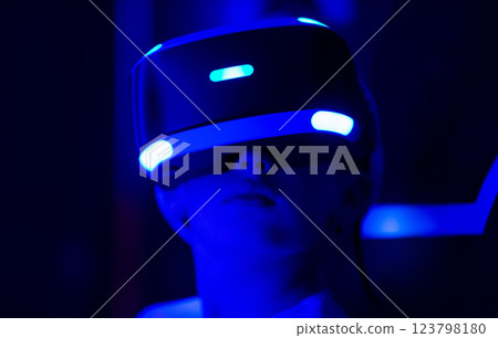 A person wearing a blue virtual reality headset. The person is looking at the camera. Concept of excitement and anticipation as the person prepares to enter the virtual world 123798180