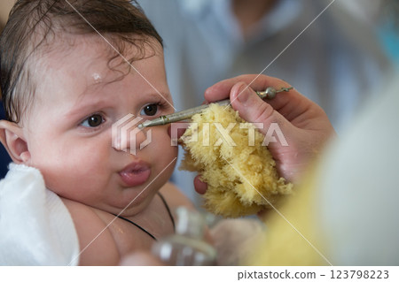 Baby at the rite of baptism. Accepting faith. Religious process of child baptism 123798223