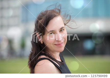 A street portrait of a middle-aged woman, she smiled and looks at the camera. A street portrait of a middle-aged woman, she smiled and looks at the camera. 123798499