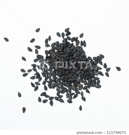 Black sesame seeds scattered on a white background macro top view Black sesame seeds scattered on a white background macro top view 123799075