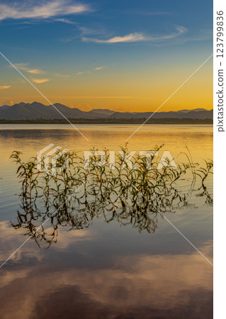 Landscape of mountains and lake at sunset and clouds reflected in the water. Landscape of mountains and lake at sunset and clouds reflected in the water. 123799836