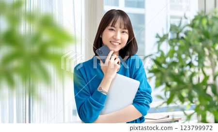 帶筆記型電腦和智慧型手機的微笑女性 123799972