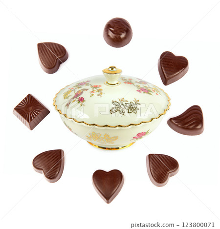 Vintage porcelain candy bowl and a set of chocolate candies isolated on white background. 123800071