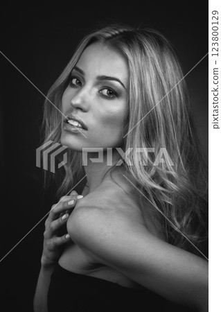 Timeless Blonde Siren: Intense Gaze and Touch on Monochrome Backdrop 123800129