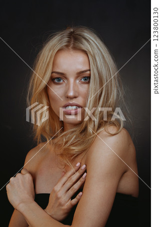 "Mystical Blonde Muse: Piercing Blue Eyes on Velvet Black Background 123800130