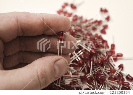 Red LED lights in your hand. Electronic LED element. 123800394