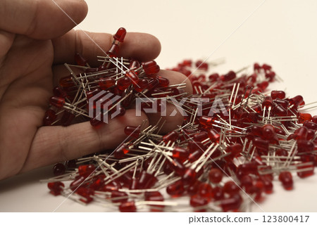 Red LED lights in your hand. Electronic LED element. 123800417