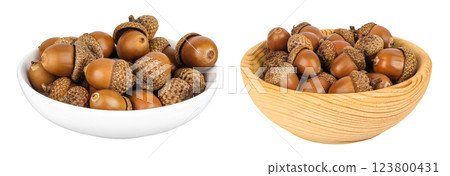 Brown acorn oak nut in ceramic and wooden bowl isolated on white background Brown acorn oak nut in ceramic and wooden bowl isolated on white background 123800431