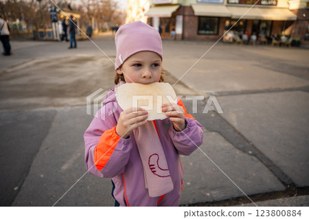 Little girl holding a typical traditional warm waffle or spa waffle in town Karlovy Vary or Carlsbad, Czech Republic Little girl holding a typical traditional warm waffle or spa waffle in town Karlovy Vary or Carlsbad, Czech Republic 123800884