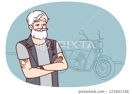 Old biker near motorcycle with tattoo on arms and gray hair wishes to travel after retirement Old biker near motorcycle with tattoo on arms and gray hair wishes to travel after retirement 123801186