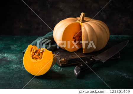 Raw fresh cut pumpkin on dark background 123801409