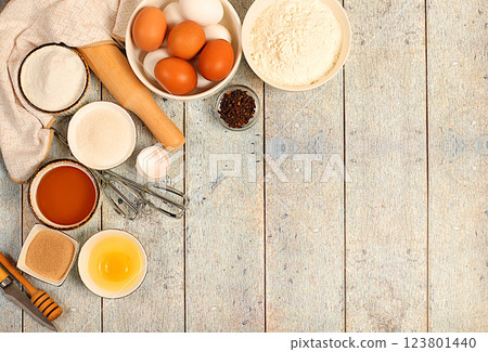 Kitchen background of food preparation with space for text. Culinary ingredients for making pie and bread, recipe with eggs, flour, sugar, honey, cinnamon, yeast and butter. Modern bakery concept, Kitchen background of food preparation with space for text. Culinary ingredients for making pie and bread, recipe with eggs, flour, sugar, honey, cinnamon, yeast and butter. Modern bakery concept, 123801440