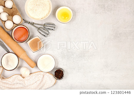 Cooking ingredients for making pie and bread, recipe with eggs, flour, sugar, honey, cinnamon, yeast and butter. Kitchen background of food preparation with space for text. Concept of modern bakery 123801446
