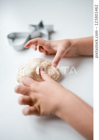 Child playing with dough on white surface 123801462