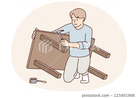 Man assembles table after buying it in furniture store and repairs DIY wooden desk for kitchen 123801906