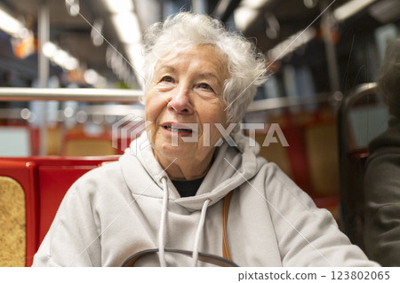 Senior woman smiling while riding public transport subway train 123802065