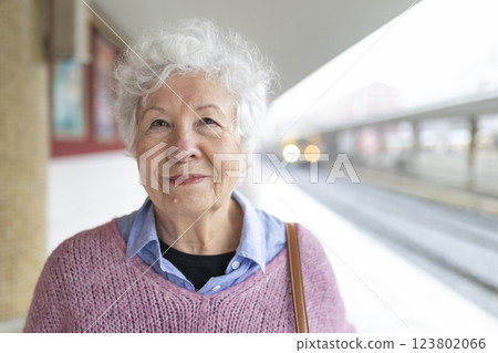 Senior woman smiling at the train station: portrait of a happy traveler Senior woman smiling at the train station: portrait of a happy traveler 123802066